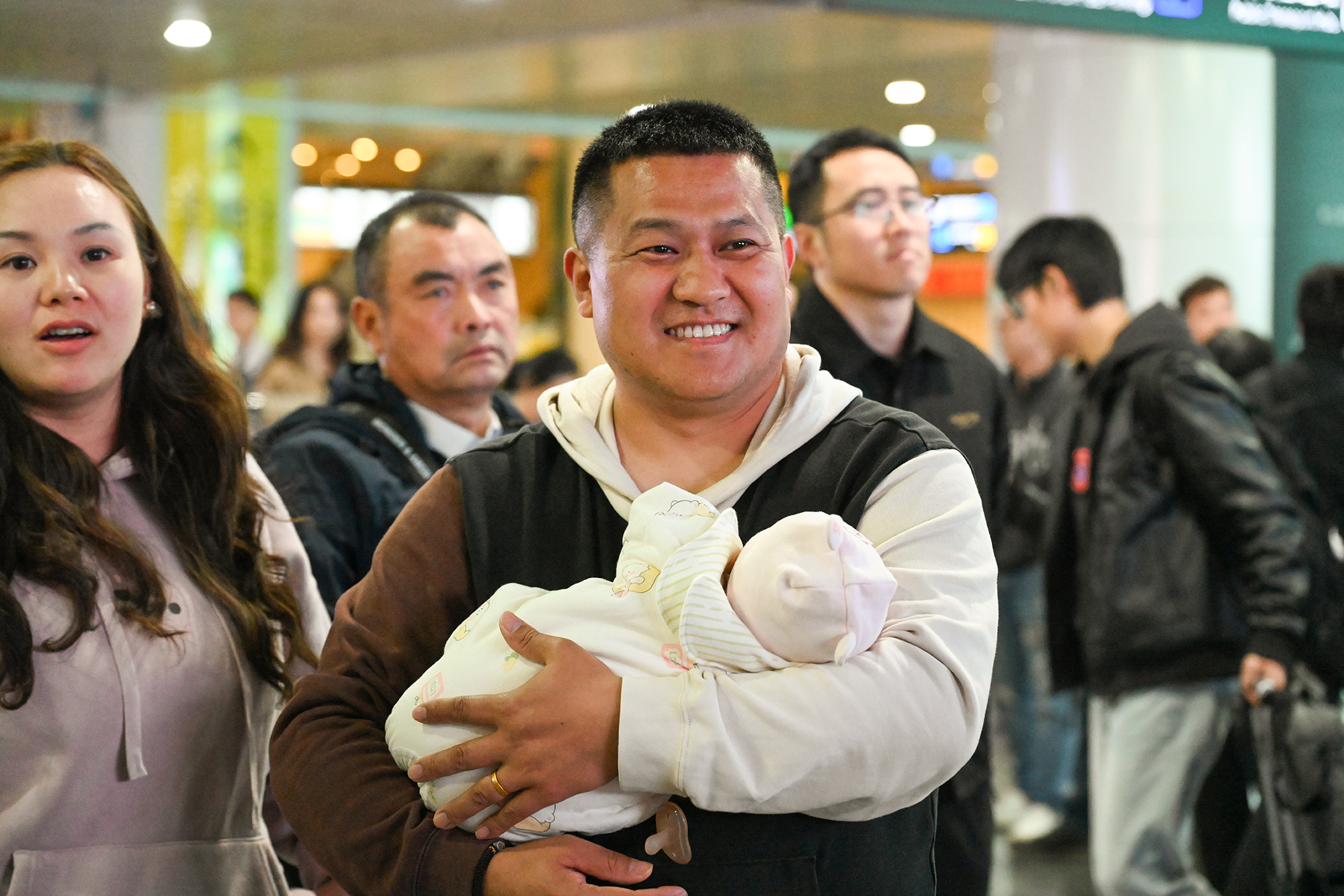 3.出站口外，奶爸带着宝宝接上亲朋团聚（汪彦彤 摄）.jpg